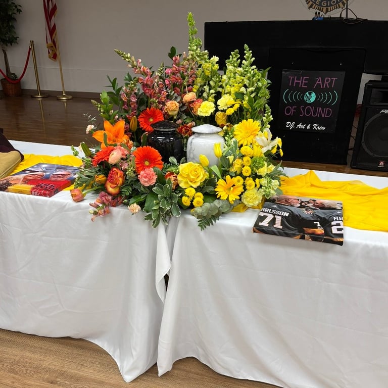 Vibrant flower arrangement with red, orange, and yellow blooms on white tablecloth at event display